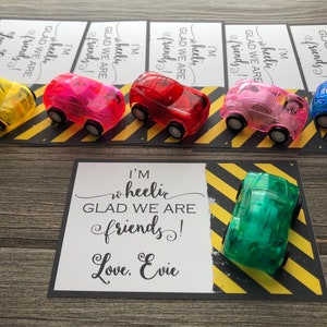 May include: A set of six colorful toy cars with a card that reads "I'm wheelie glad we are friends! Love, Evie".