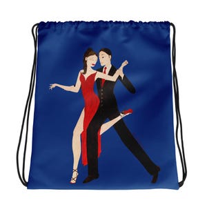 May include: A blue drawstring bag featuring an illustration of a couple dancing the tango. The woman is in a red dress, and the man is in a black suit with a red tie. The bag has black drawstrings.