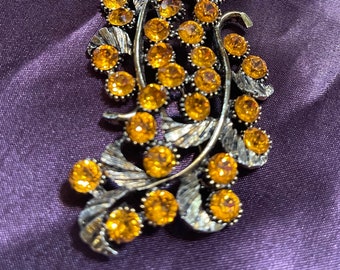 Big bold 1980s brooch with bright orange rhinestones