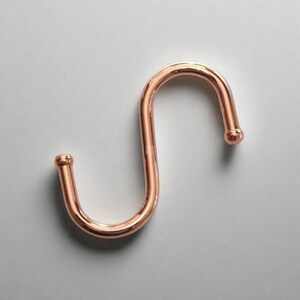 One copper S-hook which serves as a useful hook for hanging various items.