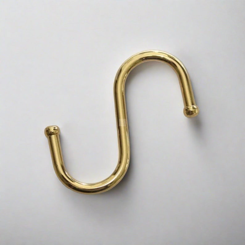 One brass S-hook which serves as a useful hook for hanging various items.