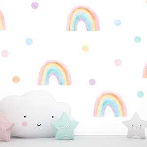 May include: A white cloud-shaped wall decal with a smiling face, surrounded by pastel rainbow and dot decals. The rainbows are in shades of pink, orange, yellow, green, and blue.