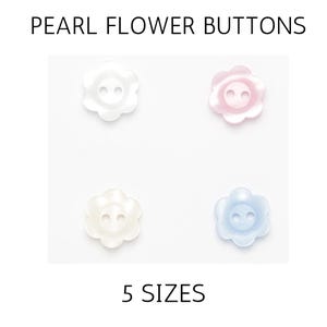 May include: Four flower-shaped pearl buttons in white, pink, and blue. Each button has two holes for sewing. The text "PEARL FLOWER BUTTONS" and "5 SIZES" are displayed above and below the buttons.
