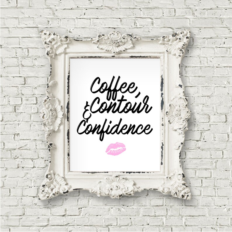 May include: White framed print with black text that reads "Coffee, & Contour Confidence" with a pink lipstick kiss mark below the text.