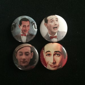 May include: Set of four round button badges featuring a man with brown hair and a red bow tie. The man is wearing a light blue suit jacket and a white shirt. The background of the badges is a light blue colour.