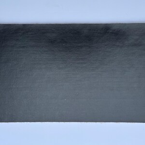 May include: A black sheet of paper with a slightly textured surface.