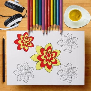 May include: A white sheet with flower designs, some colored red and yellow, others outlined in black. Colored pencils in various colors are arranged above the sheet. A cup of coffee and headphones are also visible.