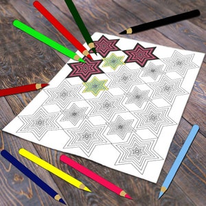 Pode incluir: Uma folha de papel branca com um desenho de livro para colorir com padr&atilde;o de estrelas. V&aacute;rios l&aacute;pis de cor, incluindo vermelho, verde e azul, est&atilde;o espalhados ao redor do papel. Algumas estrelas est&atilde;o coloridas em tons de rosa e amarelo.