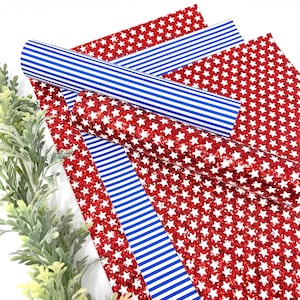 May include: Red glitter fabric with white stars and blue and white striped fabric. The fabric is perfect for crafting projects.