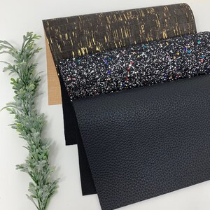 May include: Three sheets of fabric in different textures and colors. The top sheet is a brown cork fabric with gold flecks. The middle sheet is a black fabric with silver glitter and colorful flecks. The bottom sheet is a black faux leather fabric.