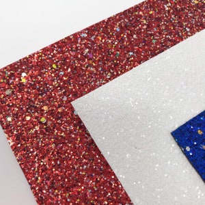 May include: Red, white, and blue glitter fabric sheets. The sheets are made of a soft, sparkly material and are perfect for crafting projects.