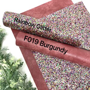 May include: A roll of burgundy faux leather with a roll of rainbow glitter fabric on top. The glitter fabric has a white base with multi-colored glitter. The text "Rainbow Glitter" and "F019 Burgundy" is printed on the fabric.