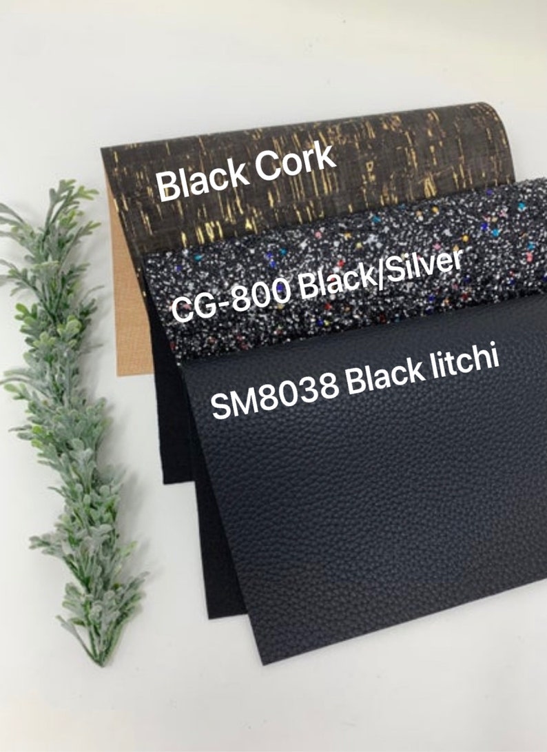 May include: Three different black fabric swatches. The top swatch is a cork fabric with gold flecks and the text "Black Cork". The middle swatch is a black fabric with silver and multi-colored glitter and the text "CG-800 Black/Silver". The bottom swatch is a black textured fabric with the text "SM8038 Black litchi".