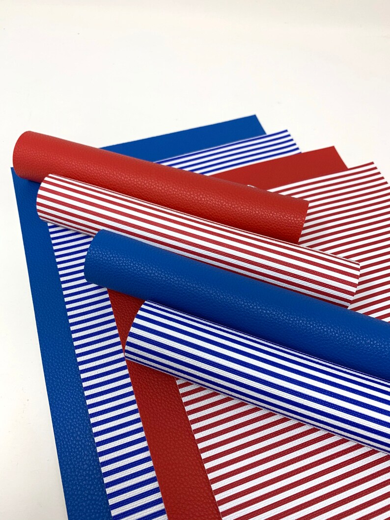 May include: A set of red and blue striped faux leather sheets. The sheets are rolled up and arranged in a stack.