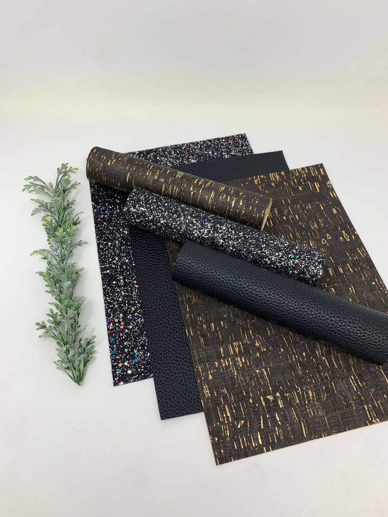 May include: A set of five black and gold patterned fabric sheets. The sheets are made of a variety of materials, including glitter, cork, and faux leather.