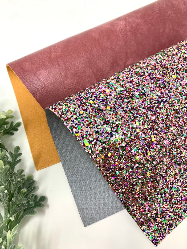 May include: Three sheets of fabric, one is a deep pink faux leather, one is a light gray textured fabric, and the last is a multi-colored glitter fabric.