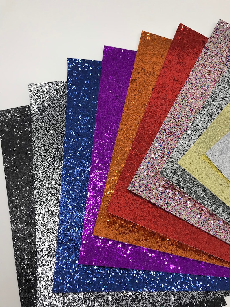 May include: Assortment of glitter paper sheets in various colors, including black, silver, blue, purple, orange, red, gold, and white.