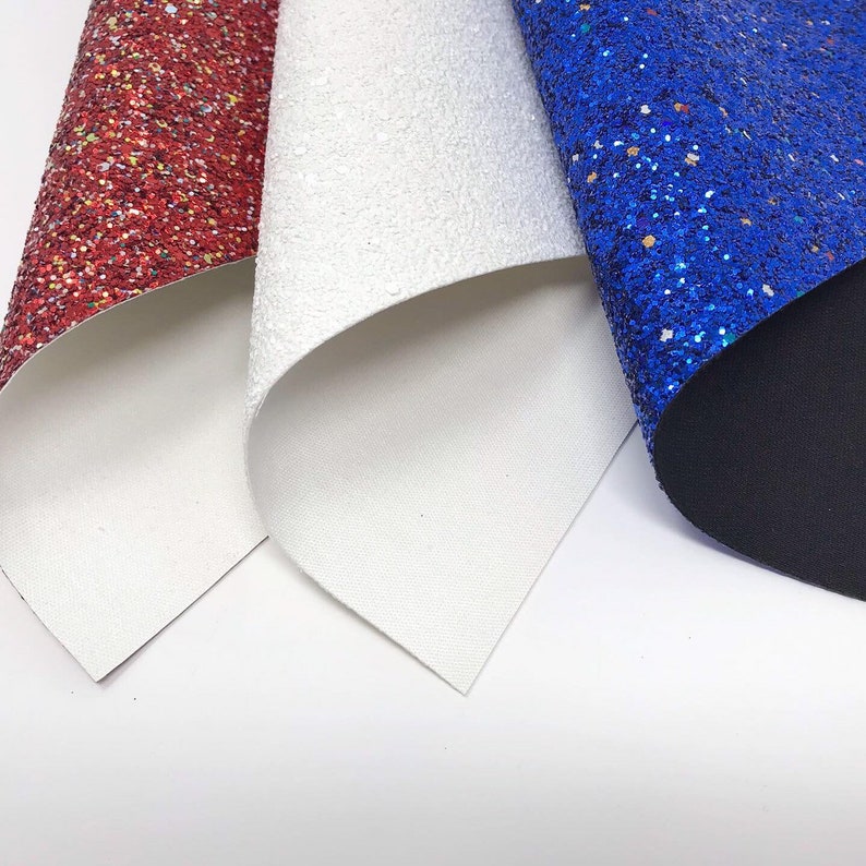 May include: Three sheets of glitter fabric in red, white, and blue. The fabric is folded in a triangular shape.