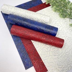 May include: Four sheets of faux leather with a rose embossed pattern. The sheets are in white, red, and blue.