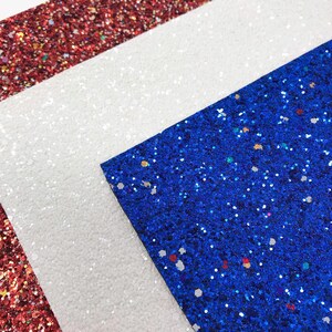 May include: Three sheets of glitter fabric in red, white, and blue. The fabric is perfect for crafting projects, scrapbooking, and more.