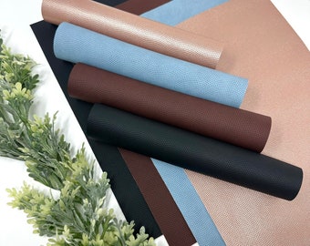 May include: Six sheets of faux leather in various colors, including black, brown, blue, and rose gold. The sheets have a textured, pebbled surface.