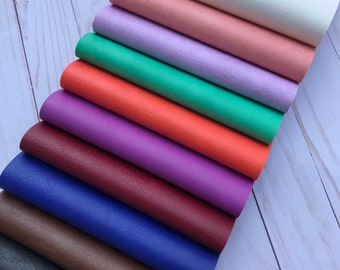 May include: A stack of ten different colored faux leather sheets. The colors are white, pink, lavender, green, orange, purple, burgundy, blue, brown, and black.
