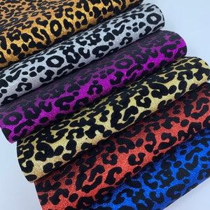 May include: Six different colors of glitter fabric with a leopard print pattern. The colors are gold, silver, purple, gold, red, and blue.