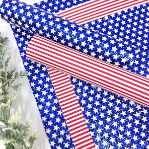 May include: Two sheets of blue glitter fabric with white stars and one sheet of red and white striped fabric. The fabric is perfect for crafting projects, scrapbooking, and home decor.