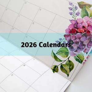 May include: A 2026 calendar with a floral design. The calendar pages are white with a grid layout. The corner features a watercolor illustration of purple and pink hydrangeas with green leaves.