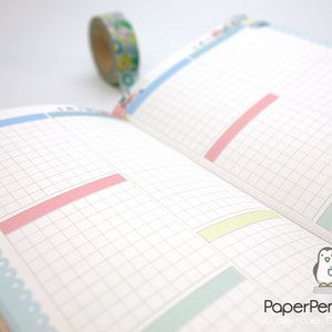 May include: Open notebook with grid paper, pastel-colored highlights, and decorative floral and blue trim. A roll of patterned washi tape is in the background. The PaperPenguinCo logo is in the bottom right corner.
