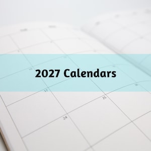May include: Open 2027 calendar with a grid layout. The text "2027 Calendars" is displayed in bold black font across a light blue band. The calendar pages are white with gray grid lines.