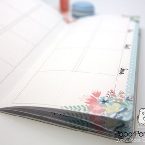 May include: Open planner with blank pages and floral corner design. The planner has a light blue border with the word "Sun" printed on the side. The Paper Penguin Co. logo is visible in the bottom right corner.