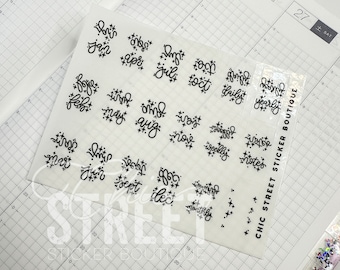 May include: A sheet of clear planner stickers with black lettering and star accents. The stickers feature the months of the year, along with words like "daily", "weekly", "notes", and "monthly".
