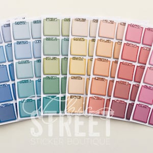 May include: A set of 10 sheets of planner stickers featuring 36 square-shaped stickers each. The stickers are in various shades of blue, green, yellow, orange, pink, and purple. Each sticker has a white border and a gold glitter accent. The stickers are labelled "The Sticker Boutique".