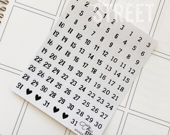 May include: A sheet of white sticker paper with black numbers 1 through 31 in circles. The numbers are arranged in rows and columns. The stickers are for use in a planner or calendar.