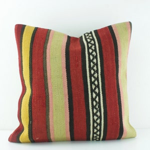 May include: A red, yellow, green, black, and pink striped throw pillow with a woven pattern.