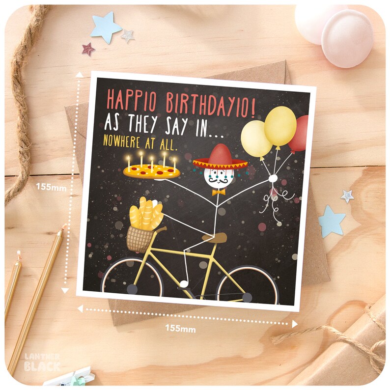 May include: A birthday card with a stick figure wearing a sombrero and riding a bicycle. The stick figure is holding a pizza with candles and balloons. The card says "Happio Birthdayio! As they say in... Nowhere at all."