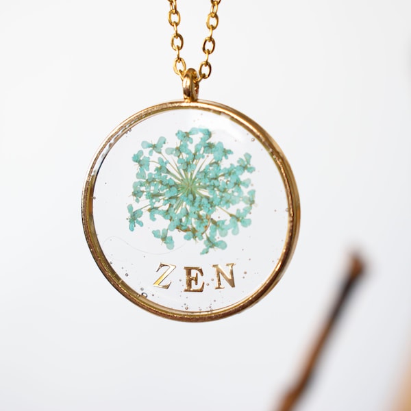 Pendentif "ZEN " et fleurs séchées. Résine UV transparente. Métal doré. Bijou original.111724