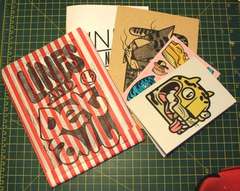 May include: A red and white striped paper bag with the text "Lines and Details" printed in black. The bag is filled with various printed papers and stickers, including a black and white illustration of a cat, a yellow and black illustration of a tiger, and a blue and white illustration of a fish.