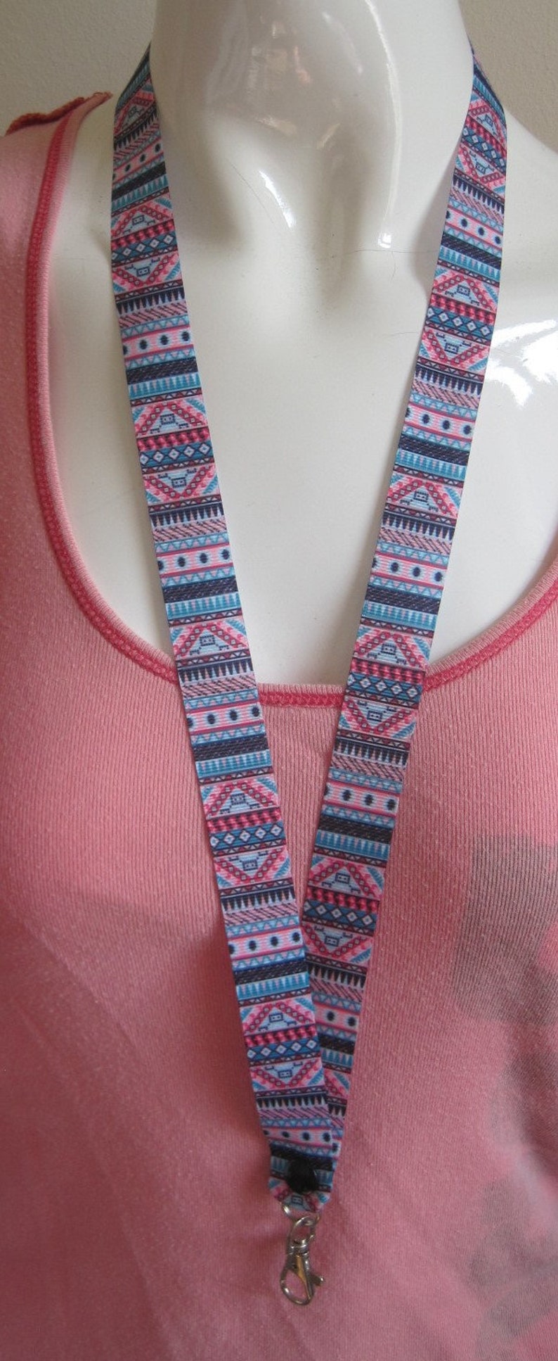 Pode incluir: Uma camisa rosa com um cord&atilde;o estampado colorido com um clipe prateado.