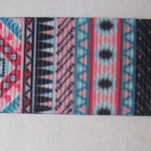 Pode incluir: Uma fita preta e branca com um padr&atilde;o geom&eacute;trico colorido. O padr&atilde;o apresenta cores rosa, azul e vermelho em um design repetitivo.