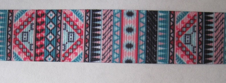 Pode incluir: Uma fita preta e branca com um padr&atilde;o geom&eacute;trico colorido. O padr&atilde;o apresenta cores rosa, azul e vermelho em um design repetitivo.