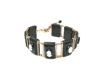 Victorian vulcanite Bracelet, Mourning bracelet, with white cameos on articulated black plaques.