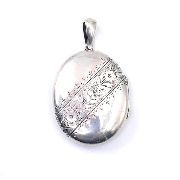 Engraved vintage locket, large oval silver locket with floral and leaf engraving diagonally across the locket.