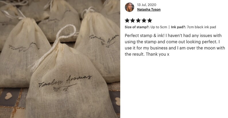 May include: Close-up of several small white muslin bags with the text "Timeless Aromas" printed on them. The bags are arranged on a textured surface. The text "Timeless Aromas" is repeated on each bag.