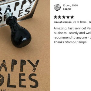 May include: A black rubber stamp with the text "SCRAPPY DOODLES" in white lettering. The stamp is on a brown surface and has a black handle. The text "SCRAPPY DOODLES" is also stamped in black ink on the brown surface.