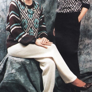 May include: Two women wearing sweaters with geometric patterns. One woman is wearing white pants and brown shoes. The other woman is wearing black pants.
