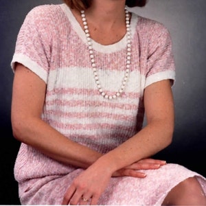 May include: A pink and white striped sweater with a white pearl necklace.