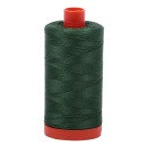 May include: A spool of dark green thread with a red plastic bobbin.