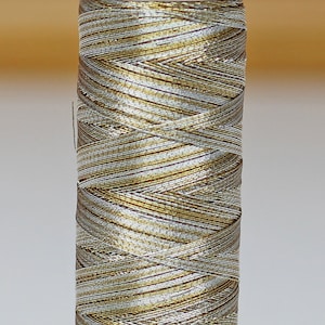 May include: A spool of gold and silver metallic thread with the text "Metallic" on the label. The number "9924" is printed on a yellow label.